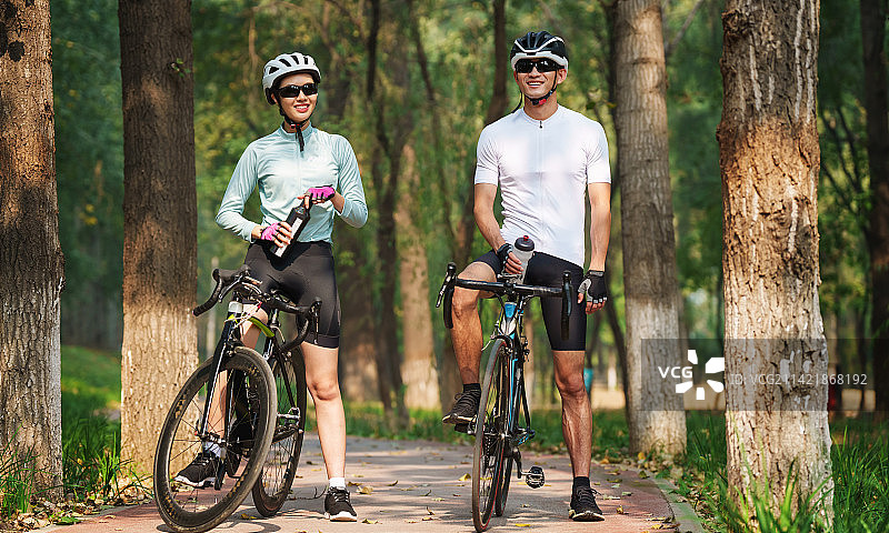 骑行的青年情侣喝水图片素材