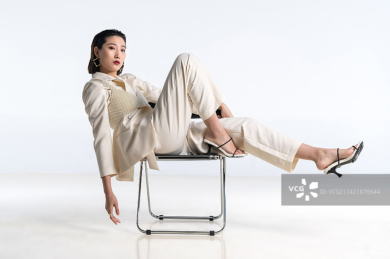 时尚青年女人坐椅子上摆造型图片素材