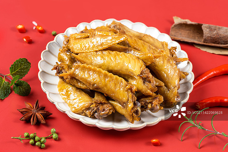 红背景上的一盘诱人卤味鸡翅尖图片素材