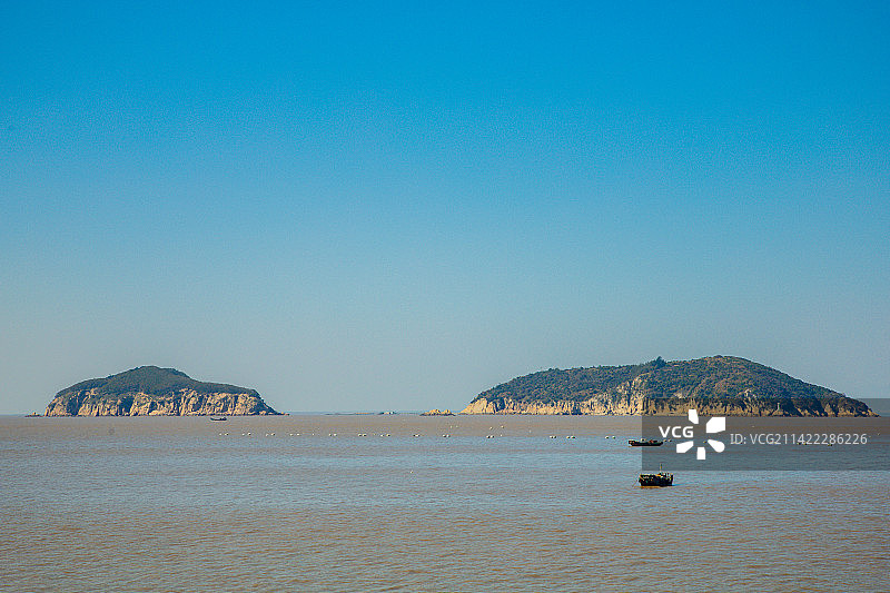 浙江省温州市洞头区洞头列岛-蓝天映衬下的海岛和渔船海景图片素材