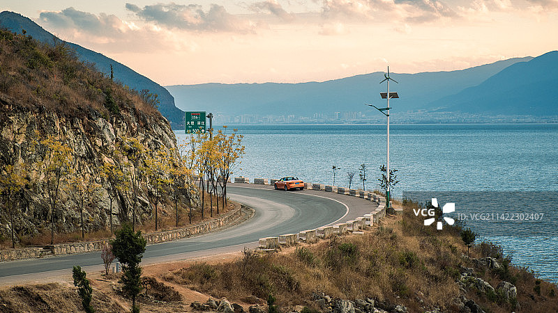 大理洱海畔的黄昏时刻，停车鹿卧山的环海拐角，遥望霞光笼罩苍山与下关市区。图片素材