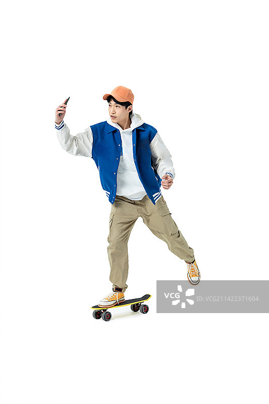 手拿手机与滑板的年轻男生图片素材