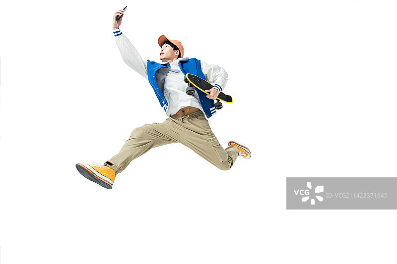 拿着手机与滑板的年轻男生图片素材