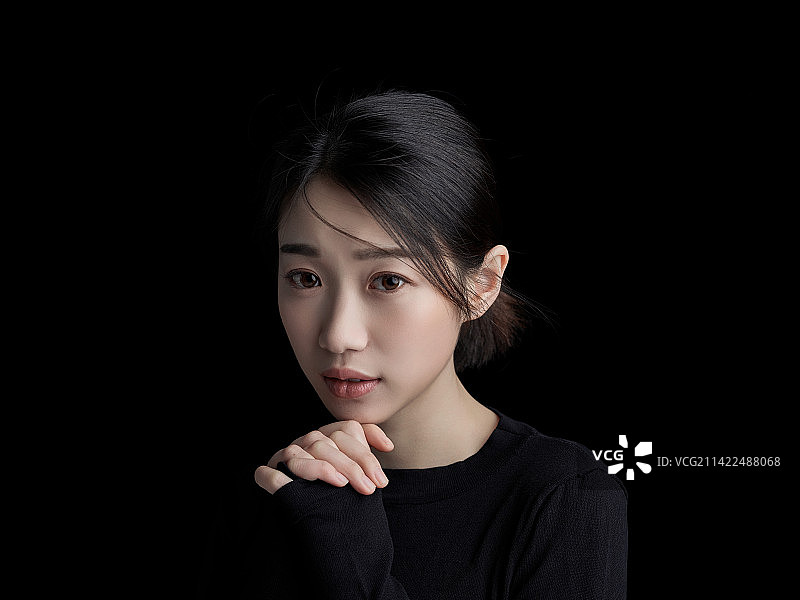 黑色背景下的年轻女子肖像图片素材