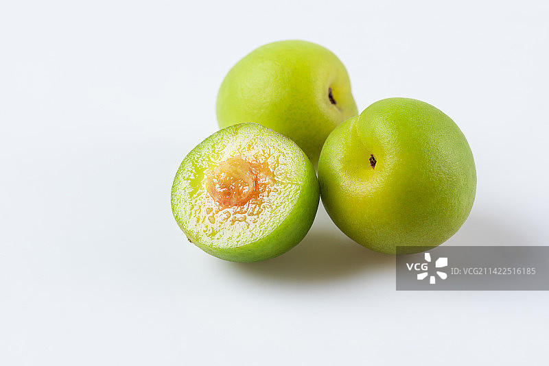 白底上切开一半的新鲜青梅图片素材