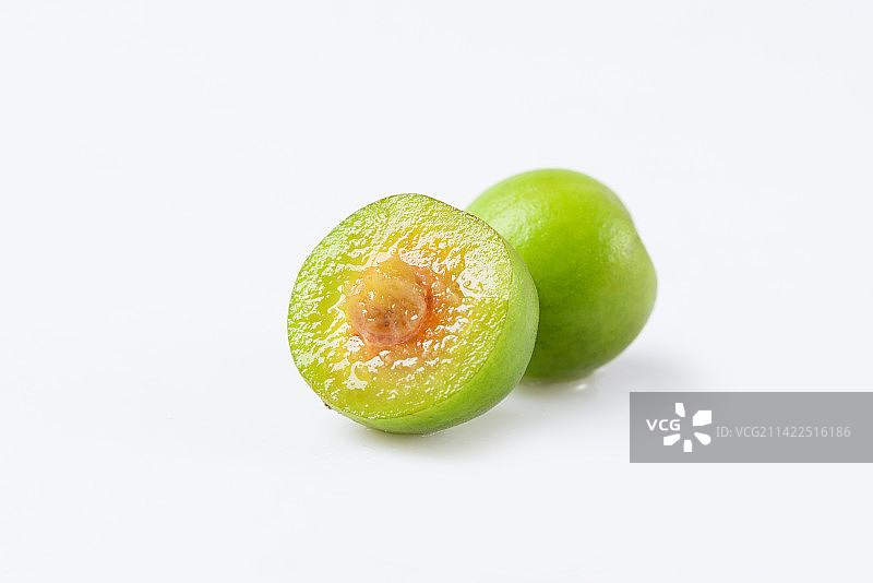 白底上切开一半的新鲜青梅图片素材