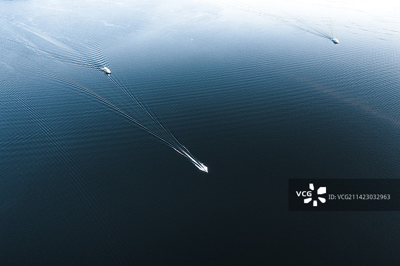 在蓝色湖面上孤独行驶的游艇图片素材