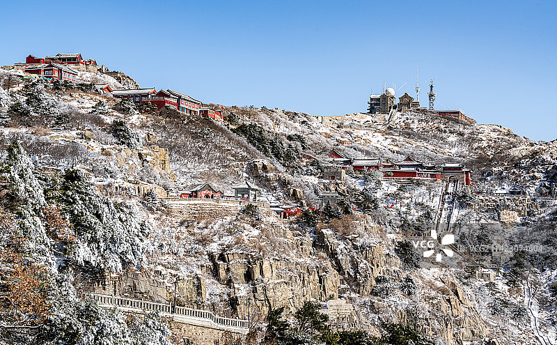 纯净蓝天与白雪背景映衬中的山东泰安泰山风景区玉皇顶古建筑群景观与日观峰气象台全景视角图片素材