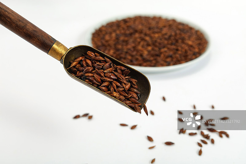 勺子里的大麦茶洒向白色背景图片素材