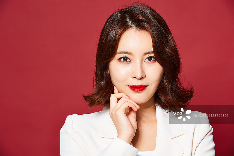 红色背景上的白色西装女子摄影图片素材