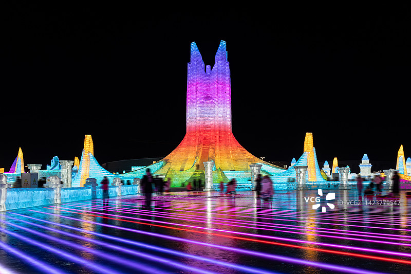 哈尔滨冰雪大世界夜晚霓虹灯照射下的冰雕以及玩耍的人群图片素材