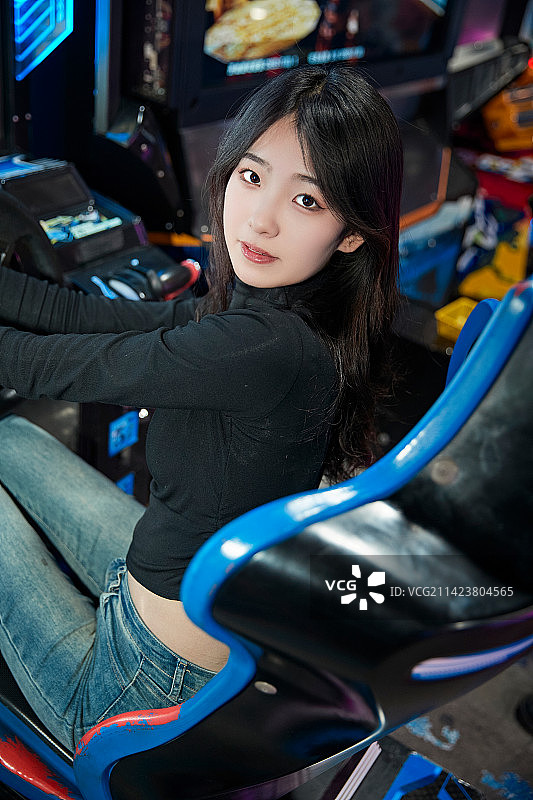 在电子游戏娱乐城玩耍的时尚少女图片素材