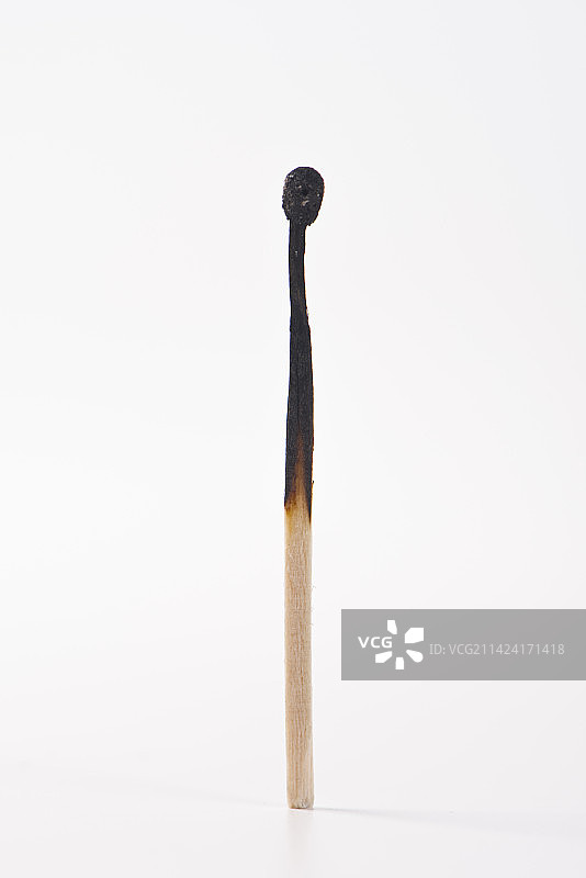 白色背景上一根燃烧过的火柴图片素材