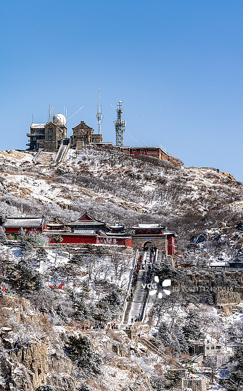 蓝天白雪背景映衬中的山东泰安泰山风景区碧霞祠西神门日观峰景点景观图片素材