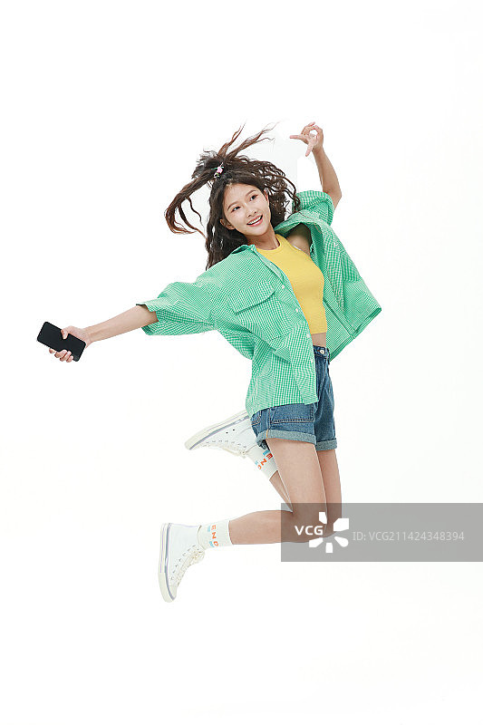 拿着手机跳跃的美少女图片素材