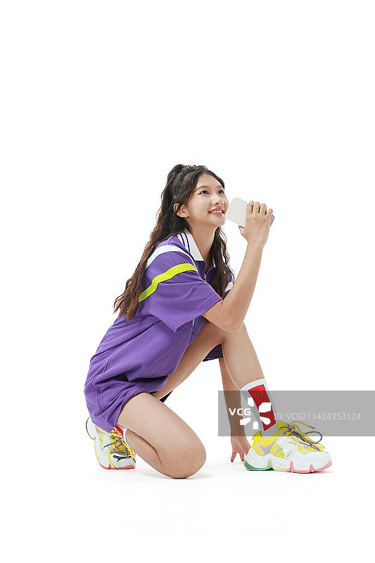 坐在地面玩手机的美少女图片素材