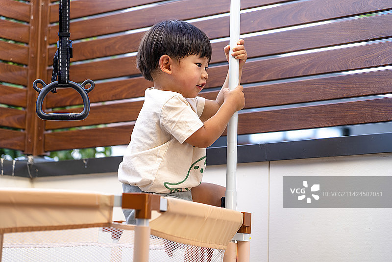大平台蹦床上玩乐的小男孩图片素材