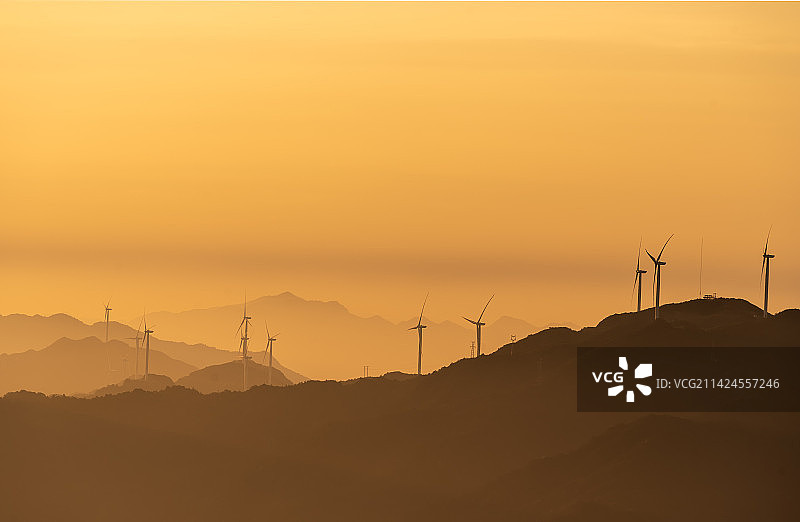 朝霞和山峦中的风车图片素材