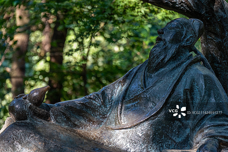 由诗仙李白而闻名的敬亭山公园一角，一束阳光射在诗仙李白横卧的铜制雕像图片素材