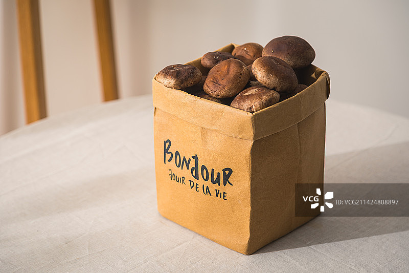 桌子上装着面包水果的牛皮纸袋子收纳袋图片素材