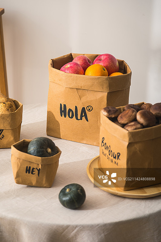 桌子上装着面包水果的牛皮纸袋子收纳袋图片素材