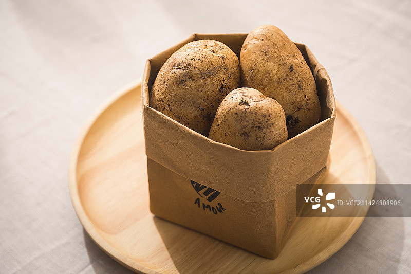 桌子上装着面包水果的牛皮纸袋子收纳袋图片素材