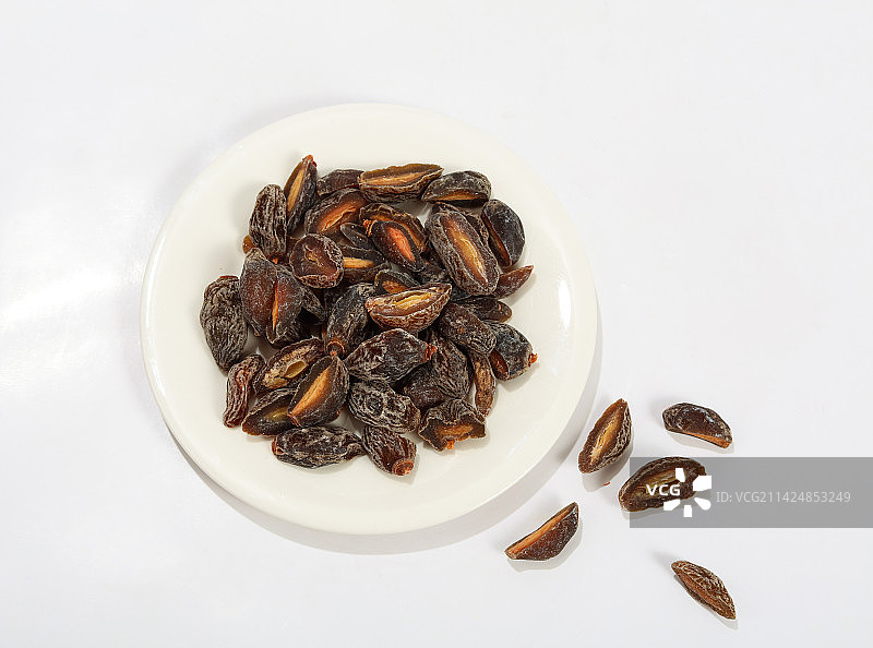 一盘甘草梅摆放在白色背景上图片素材