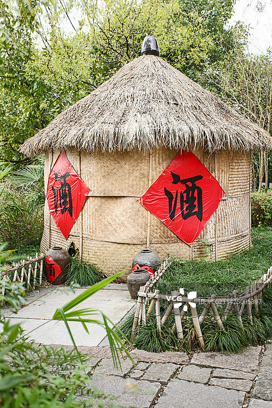 竹篾编的墙上贴有酒字的茅草酒坊酒屋图片素材