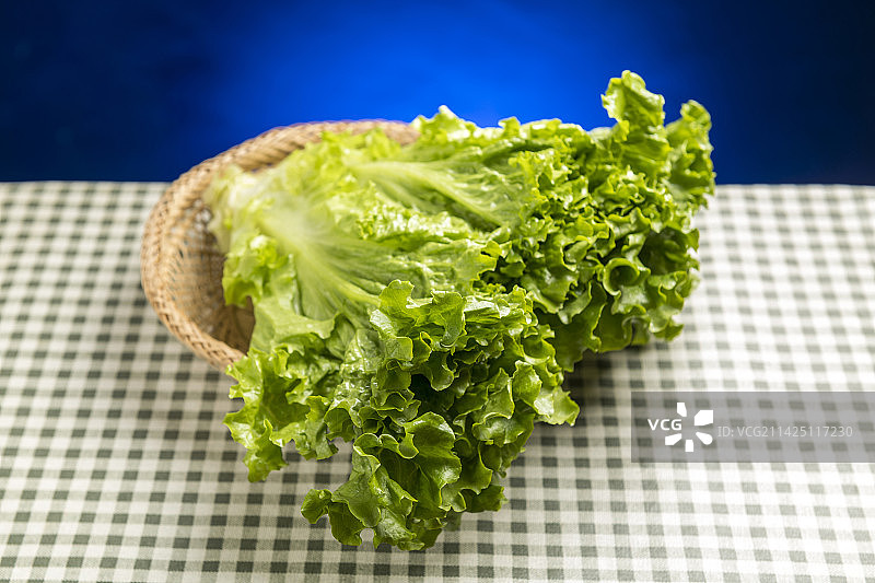一簸箕罗马生菜摆放在格子桌布上特写图片素材