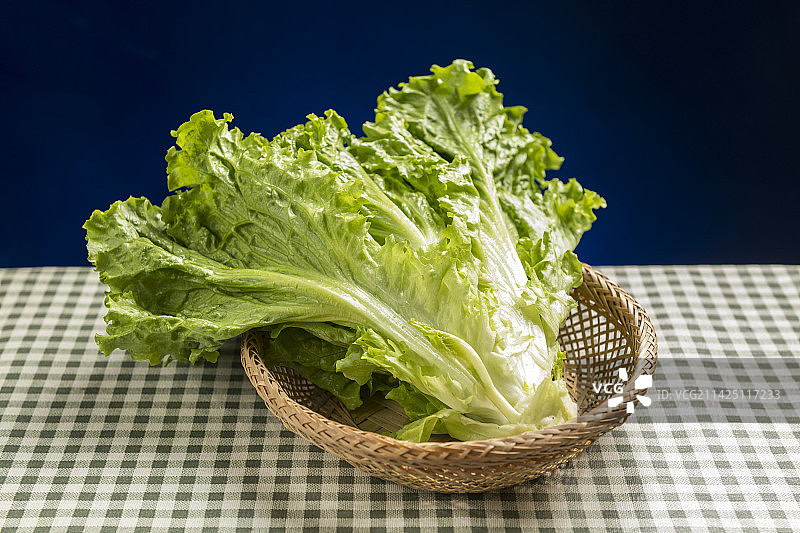 一簸箕罗马生菜摆放在格子桌布上特写图片素材