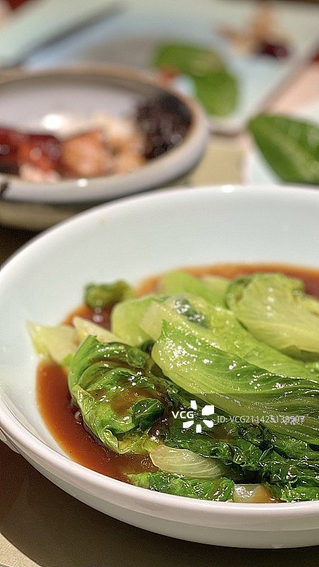 桌上盘子里食物的特写镜头 蚝油生菜图片素材