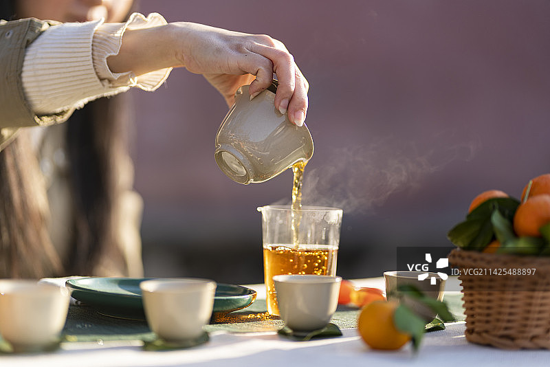 户外阳光下围炉煮茶的年轻女性图片素材