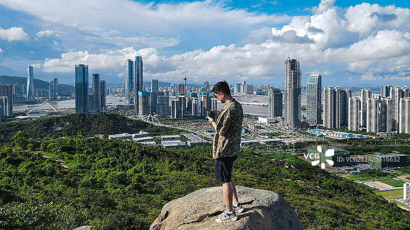 珠海小横琴山 站在山顶岩石上拍照的青年图片素材