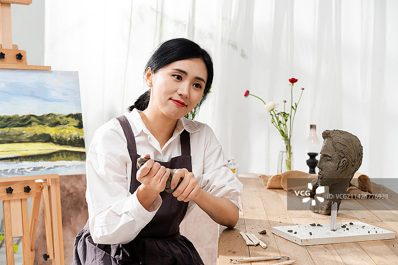 美丽的中国女艺术家在做雕像图片素材