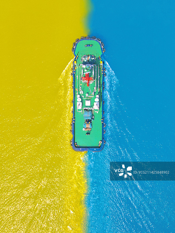 轮船驶过蓝黄海域图片素材