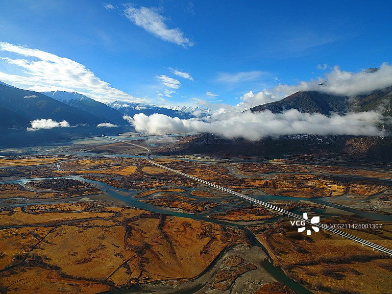 航拍西藏林芝穿越尼洋河雅尼湿地的高速公路与蓝天白云图片素材