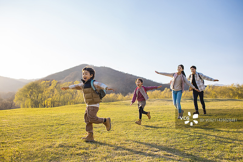 快乐的年轻家庭在草地上玩图片素材