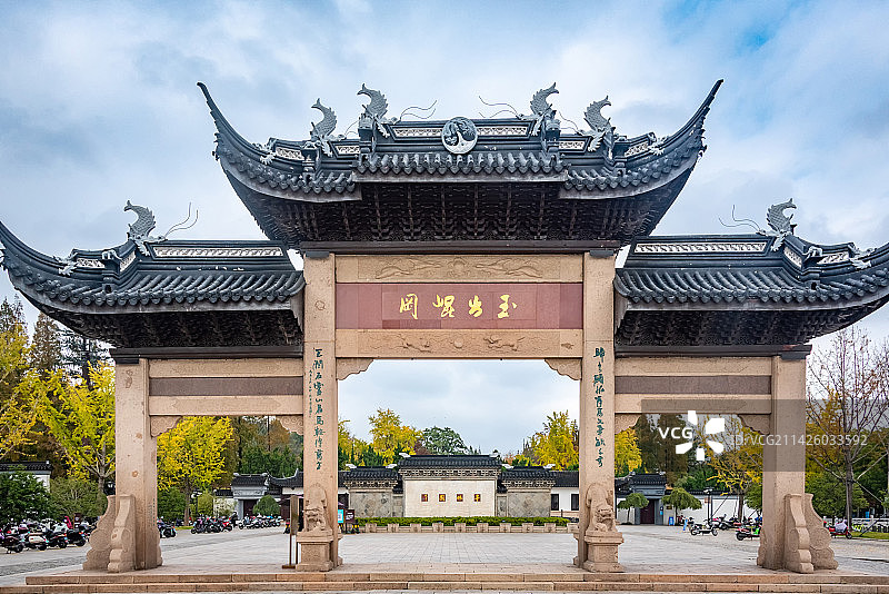 蓝天白云下昆山亭林园古色古香的牌坊和照壁，上书亭林园和玉出昆冈图片素材