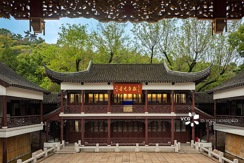 蓝天白云下，透过昆山亭林园昆曲博物馆里的戏台木雕看见对面古色古香的两层小楼，牌匾上书盛世元音图片素材