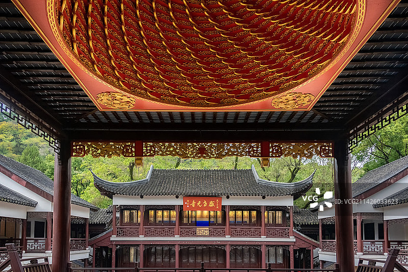 蓝天白云下，透过昆山亭林园昆曲博物馆里的戏台红色螺旋藻井看见对面古色古香的两层小楼，牌匾上书盛世元音图片素材