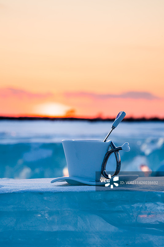 日落时分冰面上的一杯热咖啡图片素材