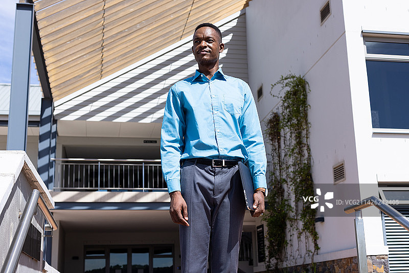 快乐的非洲裔女商人边走边用智能手机交谈图片素材