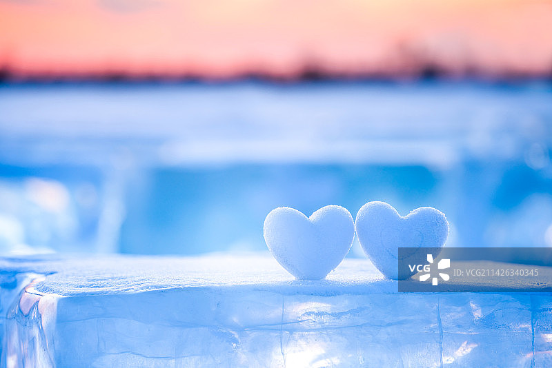 夕阳下的两个心形雪球，情人节主题图片素材