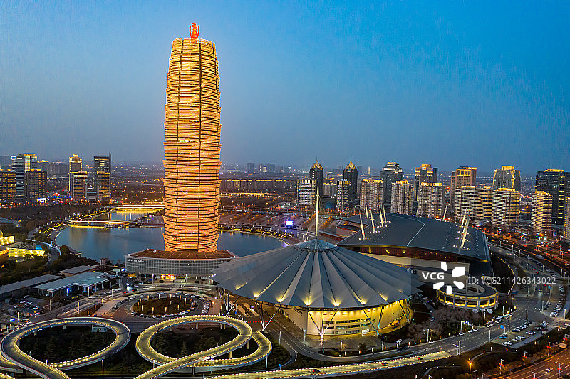航拍河南郑州大玉米楼夜景灯光秀 郑东新区CBD如意湖畔千玺广场 城市地标建筑黄色景观灯 都市天际线图片素材