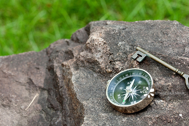 户外不规则岩石上的指南针图片素材