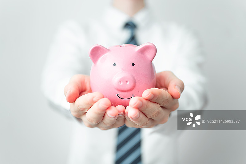 商务人士双手捧着小猪存钱罐图片素材