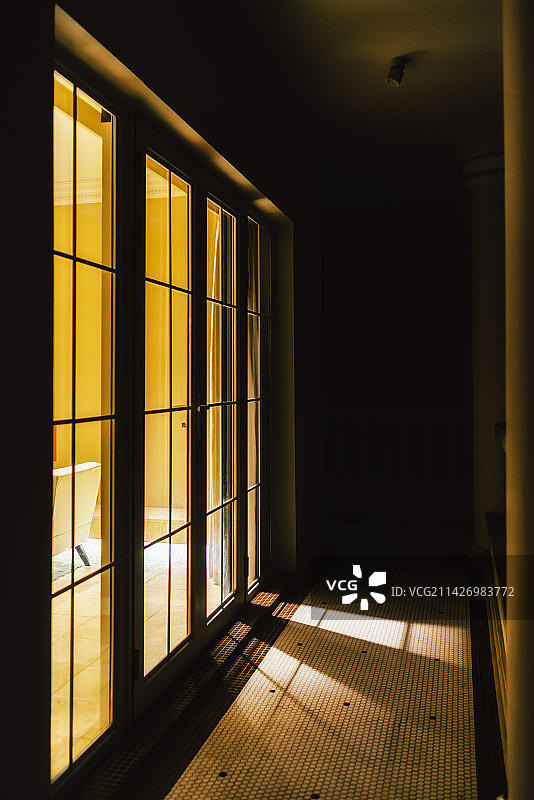 室内的光线透过落地窗投射到走廊上图片素材