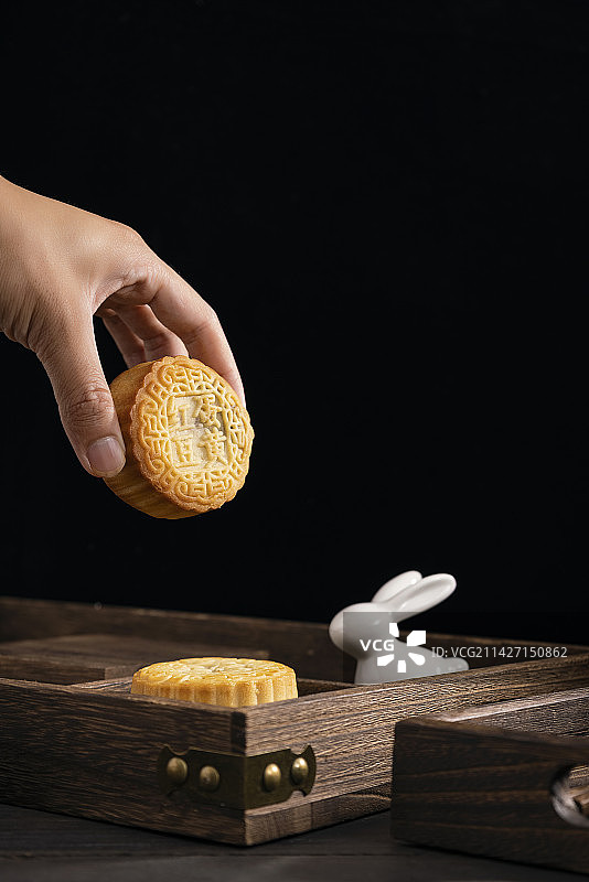 手拿月饼黑色背景中式氛围图片素材