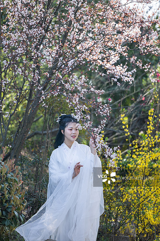 穿着传统汉服服装的中国女性站在古代建筑物旁边的肖像图片素材