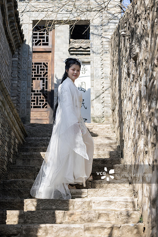 穿着传统汉服服装的中国女性站在古代建筑物旁边的肖像图片素材